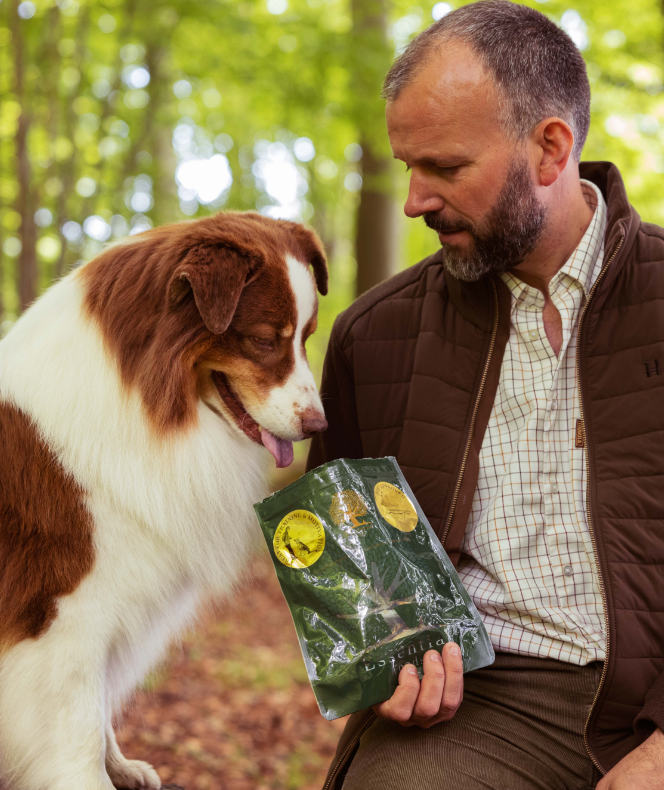 En mand med en pose med VIGTIGSTE bittesmå fiskelækkerier - små lækre hundesnacks, bæredygtigt fanget i Østersøen.