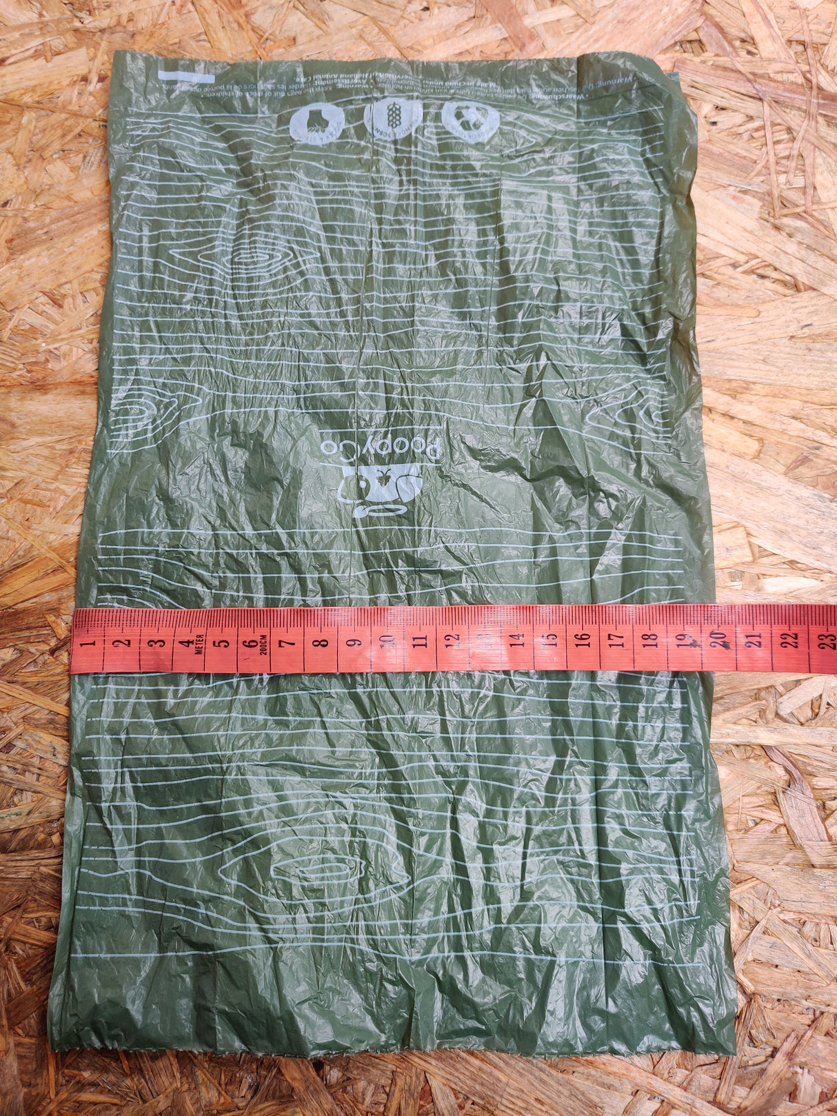 En Høm Høm hundeposer, miljøvenlig fra PoopyGo taske med et målebånd på.