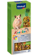 En hamster, der glad gumler på Vitakraft Kräcker, tandslibende stænger til hamster i en kasse mad.