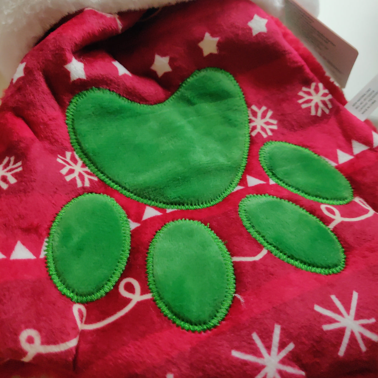 En rød og grøn nissehue med poteprint Kong - Holiday Stocking Paw.