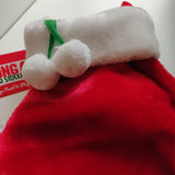 En rød Kong - Holiday Stocking Paw med pom poms på, perfekt til feriesæsonen.