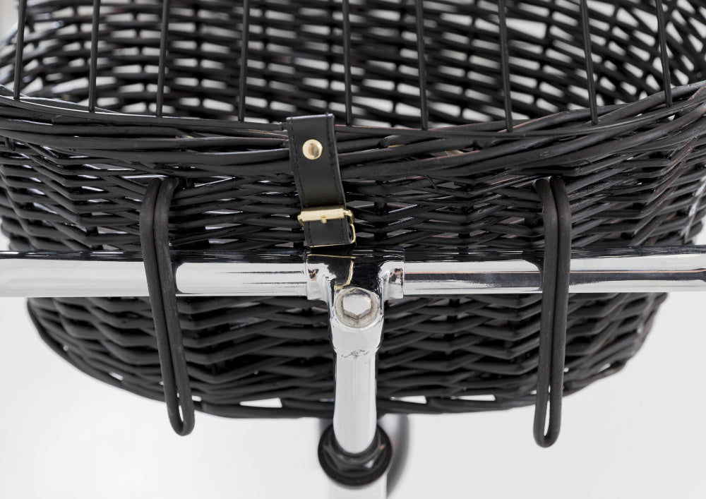 Et nærbillede af en sort Trixie flet kurv på en Farve cykel.