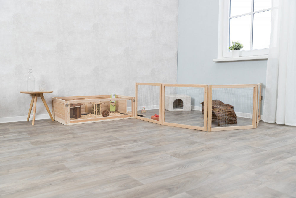 Et værelse med trækasse og trægulv, perfekt til at rumme Trixies løbegård indendørs - til marsvin og kaniner.