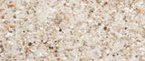 Et nærbillede af Fuglesand med anis af Versele-Laga, en hvid struktureret overflade.