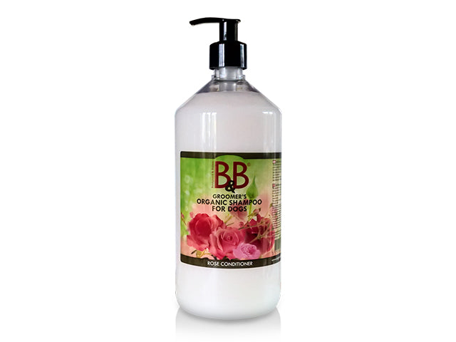 En flaske B&B økologisk hundebalsam med Rosenolie med roser på hvid baggrund.