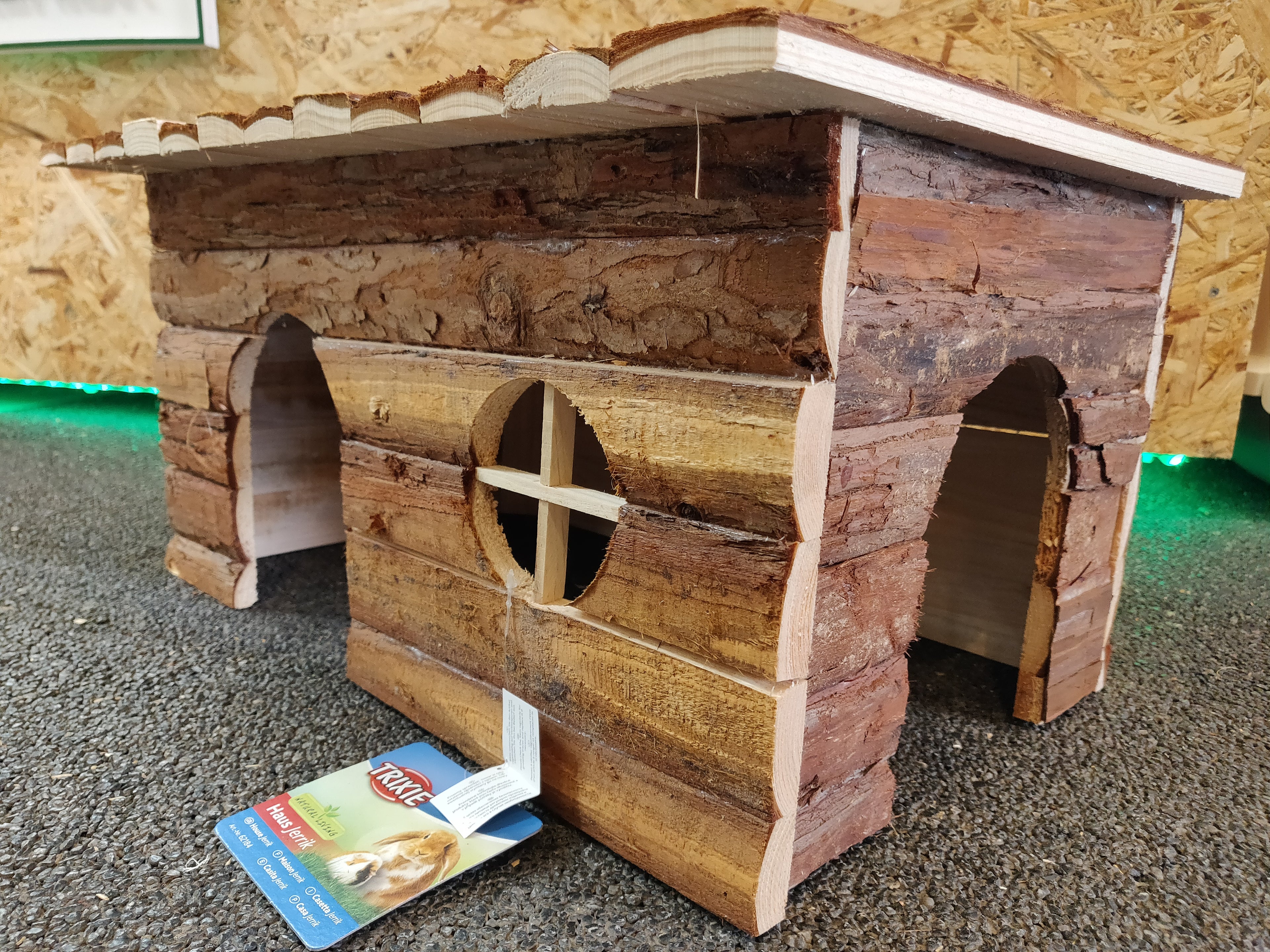 A Natural Living "Jerrik" træhus til gnavere med et skilt på.