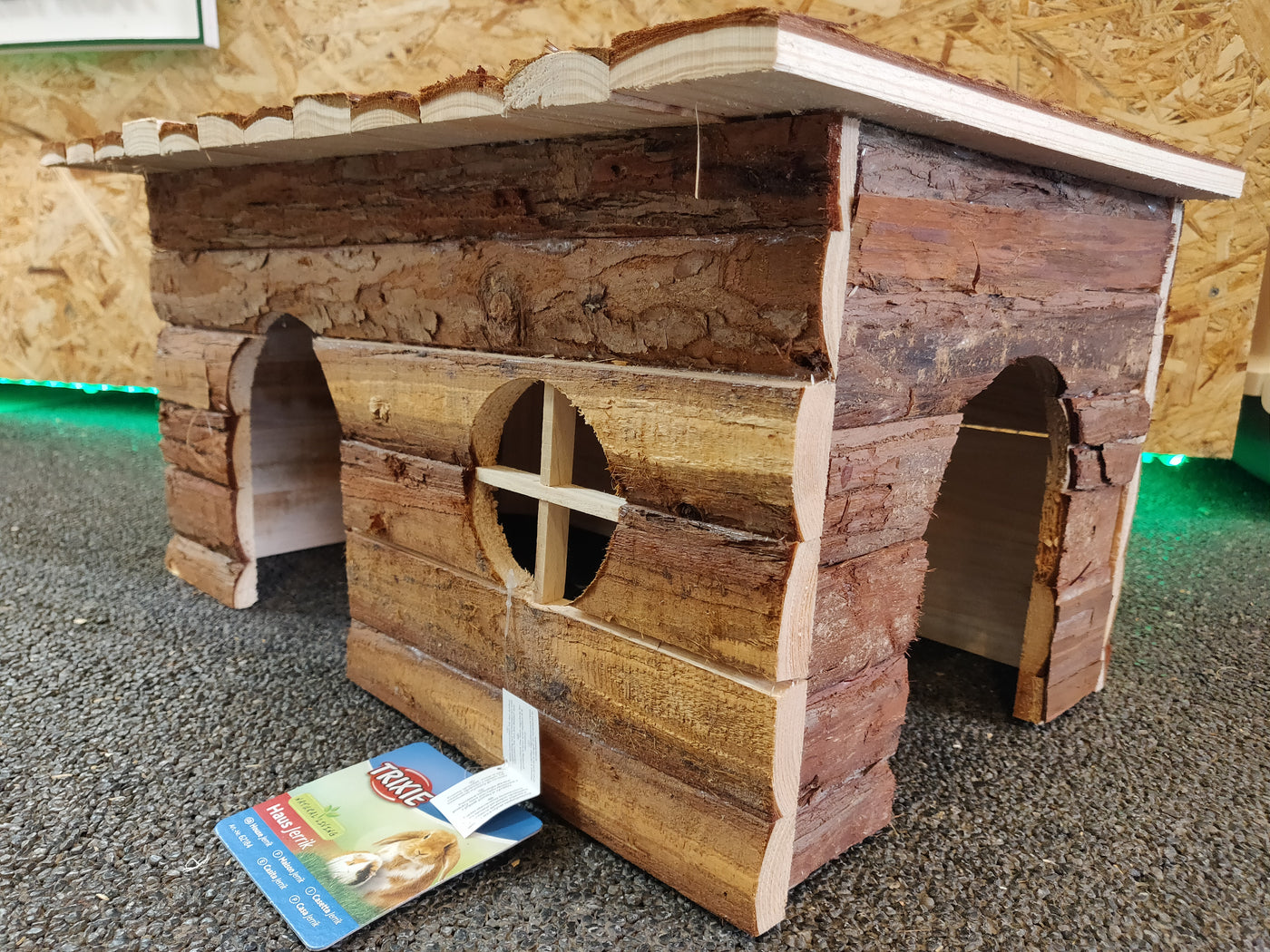 A Natural Living "Jerrik" træhus til gnavere med et skilt på.