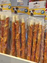 En udstilling af hundegodbidder, herunder Tyggepinde m/ kylling (28cm, 3-pak) og oksehud, udstillet i en butik. Mærkenavn: Jolly