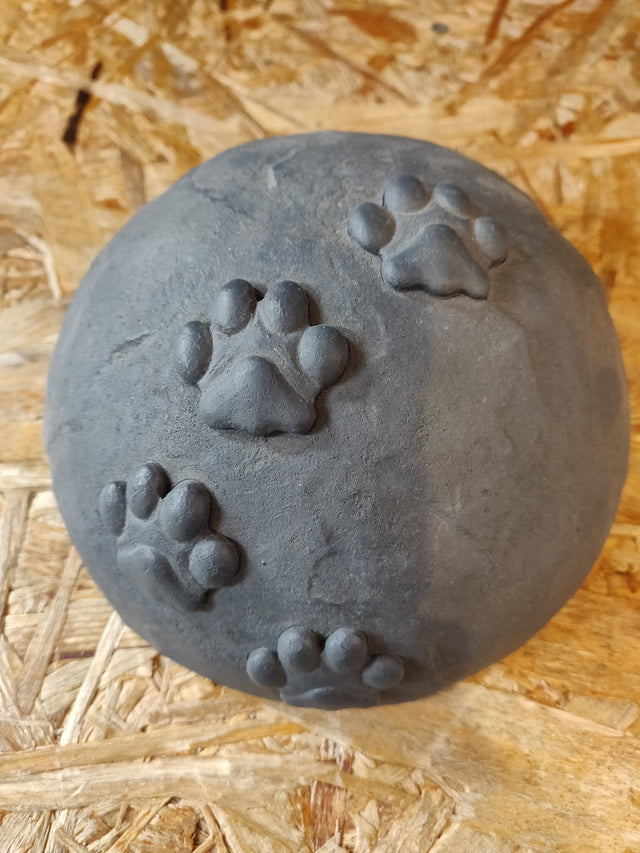 En Gravsten lerkugle med poteaftryk på, der måler 15 x 8 cm.
