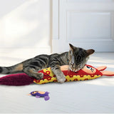 En kat leger med et Kong Kickeroo Kanga kattelegetøj på gulvet.