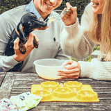 En mand og kvinde fodrer en gravhund med Smoofl-godbidder.