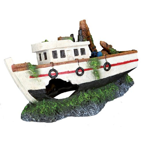En model af Akvariepynt Kutter Skibsvrag-båden, der sidder på toppen af græs. (Mærke: Trixie)