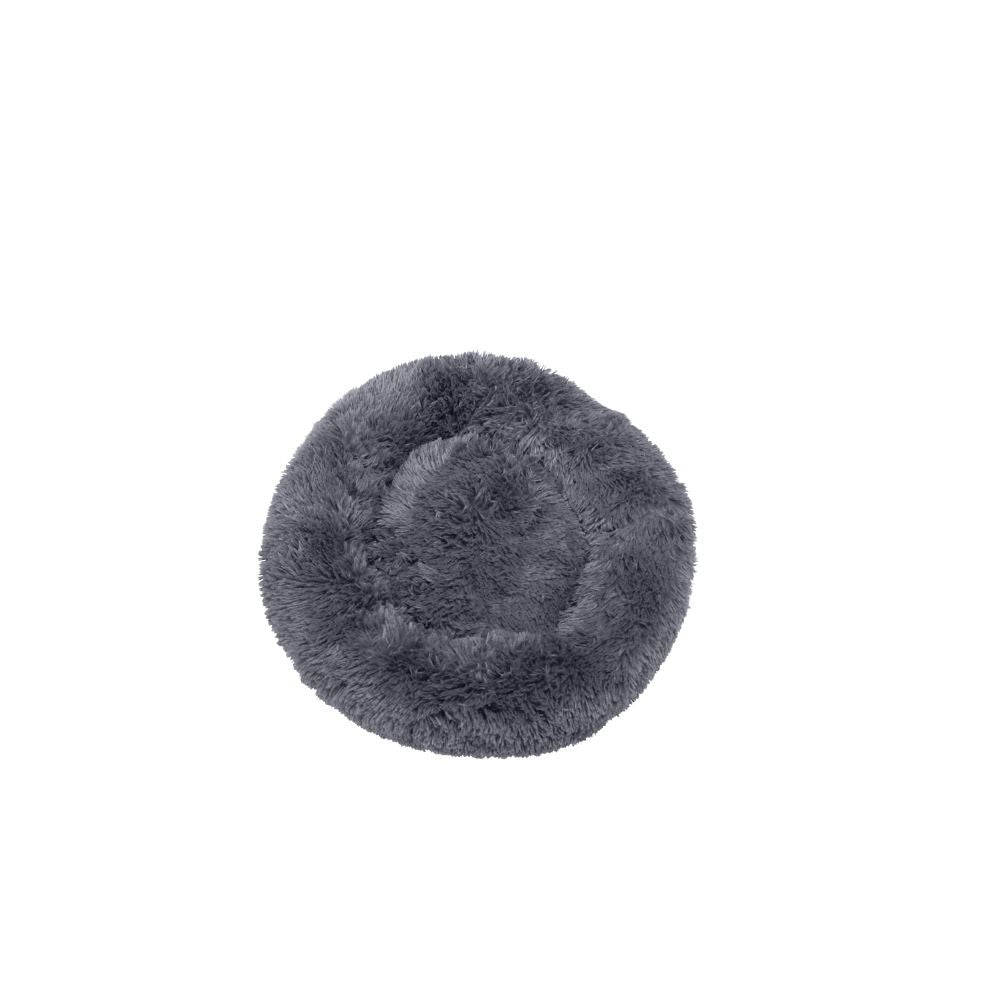 En rund hundeseng lavet af fluffy gråt fåreskindsmateriale på hvid baggrund.