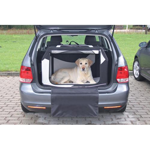En hund sidder i bagagerummet på en bil, omgivet af Trixie "Vario" Hunde Transportbur og beskyttet af en netindsats af polyester.
