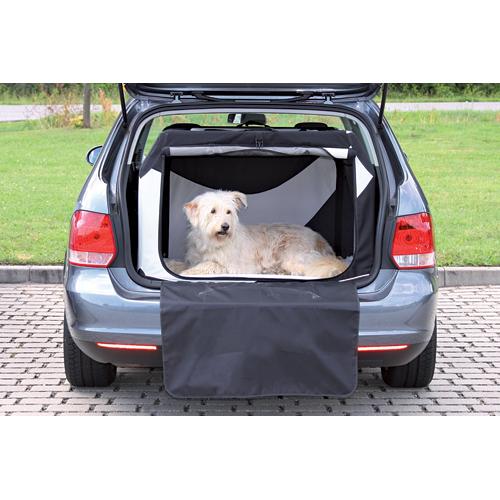En hund sidder i bagagerummet på en bil, sikkert indeholdt i en Trixie Hunde Transportbur "Vario" lavet af polyester og metalstænger.