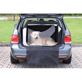 En hund sidder i bagagerummet på en bil, sikkert indeholdt i en Trixie Hunde Transportbur "Vario" lavet af polyester og metalstænger.