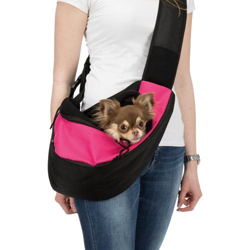 En kvinde holder en lille hund i en sort og pink Trixie Sling Front Bag.