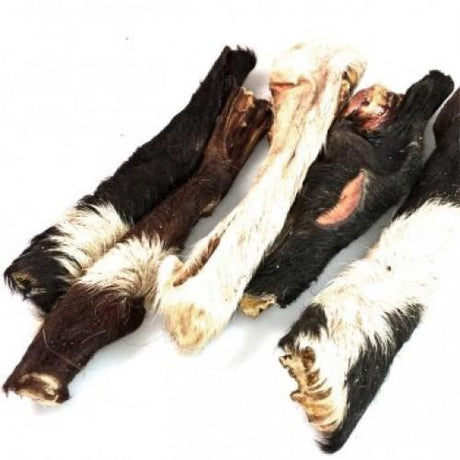 En gruppe Oksehud med pels hundeknogler lavet af Whesco, høj i protein, placeret på en hvid overflade.