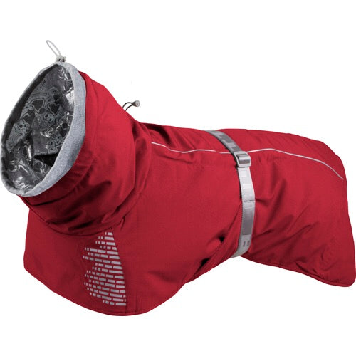 En Hurtta - Extreme Warmer Rød (Tyttebær) hundefrakke med en justerbar ryglængdebeskyttende hætte på hvid baggrund.