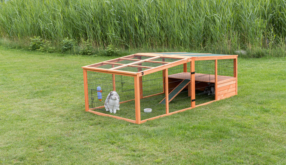 En Natura udendørs indhegning til kaniner og marsvin i et græsklædt område.